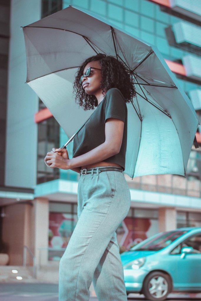 A black lady protecting her self with an umbrella 