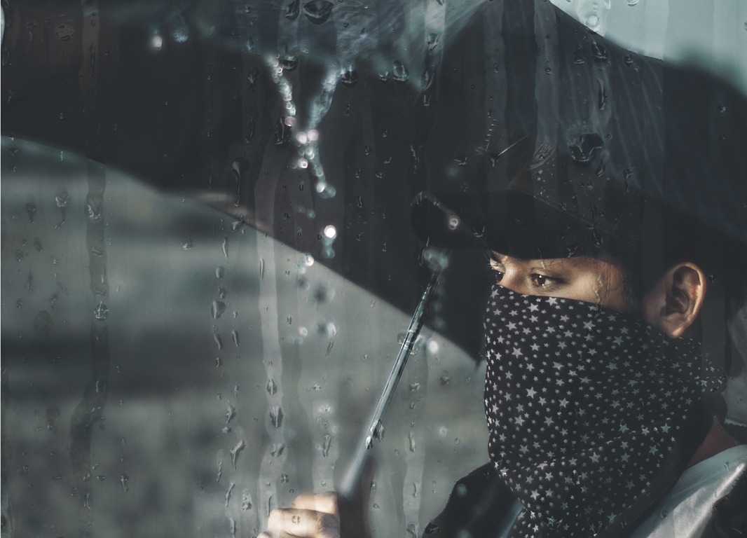 Woman carrying black umbrella in the rain